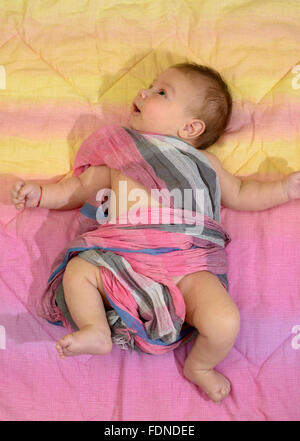 Newborn baby boy wrapped in a pink scarf Stock Photo