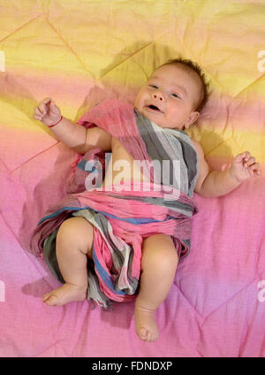 Newborn baby boy wrapped in a pink scarf Stock Photo