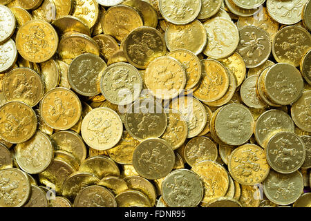Pile of gold chocolate coins creating a shiny textured background symbolising wealth, savings or festive celebration. Stock Photo