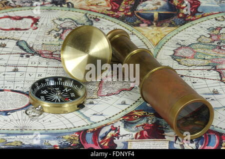 Vintage lunette and compass lying on the old map of the world. Stock Photo