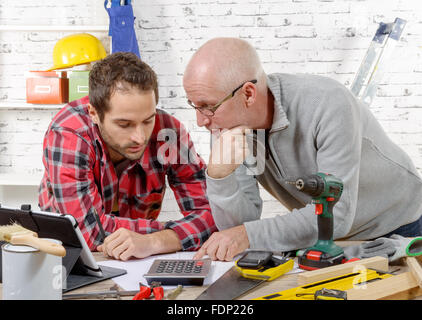 two technicians read a plan in the workshop Stock Photo