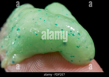 Close up of microbeads in a exfoliating face scrub on the tip of a finger. Stock Photo