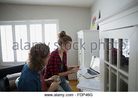 Couple with coffee at laptop paying bills online