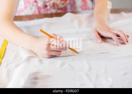 close up of dressmaker at work making patterns of fabric Stock Photo