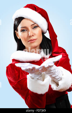 Santa Girl presenting your product, in costume and white gloves Stock Photo