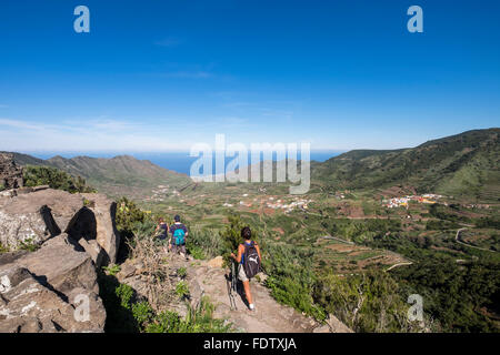 Walkers with spectacular views over the valley of Palmar in Buenavista del Norte from a walking trail on the ridge. Tenerife, ca Stock Photo