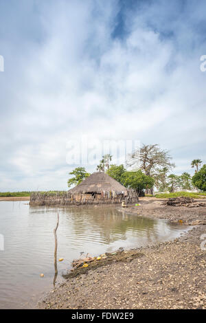A woman returning to her home in the northern Guinea Bissauan village of Elia after fishing Stock Photo