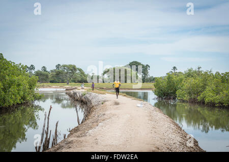 Villagers walk along a path from Elia to the main road Stock Photo