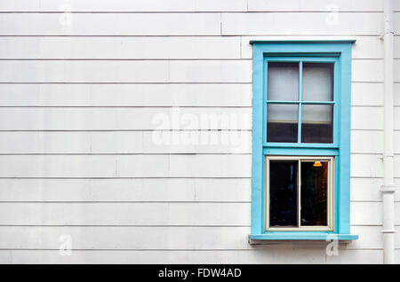 Blue framed window on white panel wall, background with copy space Stock Photo