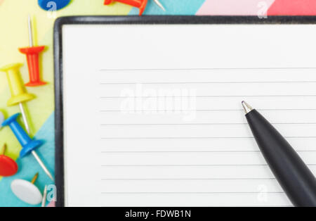 Notepad with pen and pushpins. Close-up photo Stock Photo