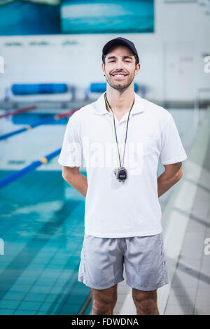 handsome swim trainer with timer standing at competition swimming pool  Stock Photo by LightFieldStudios