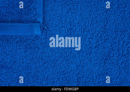 Dark blue terry towel as a seamless background with one corner Stock Photo