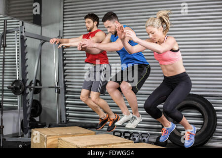 Fit people doing exercises with box Stock Photo