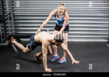 Woman trainer assisting man Stock Photo