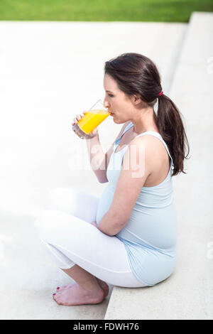 Pregnant woman sitting on stairs Stock Photo