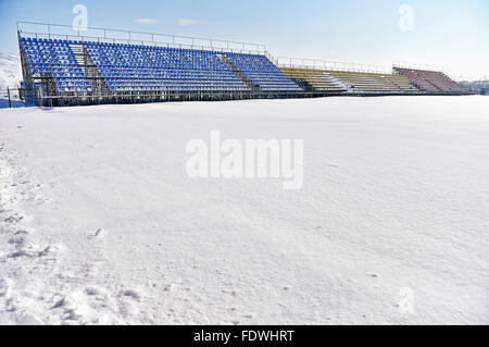 Empty tribunes and a football stadium covered in snow after a heavy snowfall Stock Photo