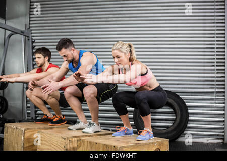 Fit people doing exercises with box Stock Photo