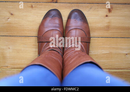 Brown leather boots and jeans caught in the rain Stock Photo