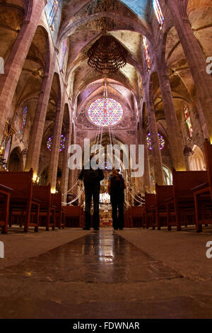 People seen walking inside palma cathedral before a sunday mass Stock Photo