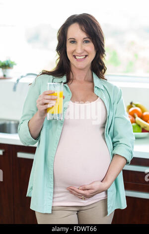 Pregnant woman holding a glass of orange juice , isolated on white ...