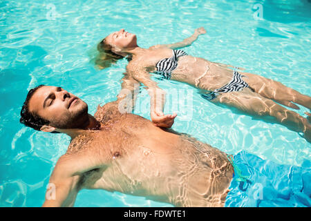Peaceful couple floating in the pool Stock Photo