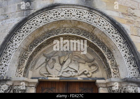 Tympanum of the Eglise de Saint-Michel in the outskirts of Angouleme France, showing the archangel St Michael slaying the dragon Stock Photo