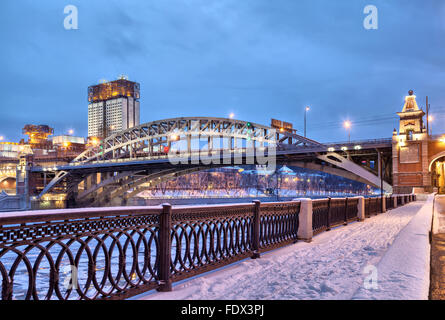 Embankment of Moscow river near Andreevsky railroad bridge and building of Science Academy in the evening, Moscow, Russia Stock Photo