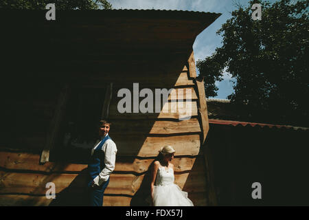 beautiful young wedding couple stands near house Stock Photo