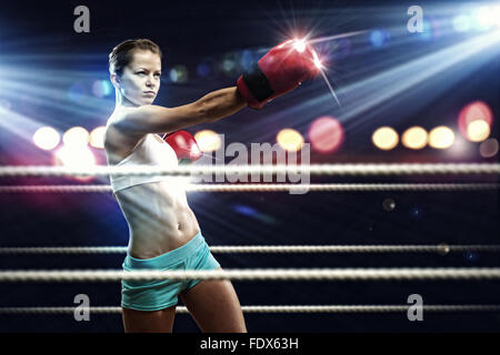 Young pretty boxer woman standing on ring Stock Photo