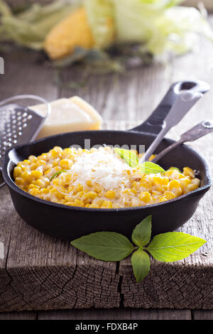 Creamy corn with parmesan in cast iron pan Stock Photo