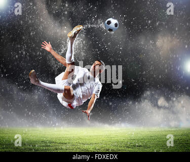 Image of football player at stadium hitting ball Stock Photo