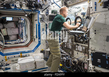 NASA astronaut Tim Kopra sets up hardware for the Burning and Suppression of Solids Ð Milliken, or BASS-M, experiment aboard the International Space Station January 27, 2016 in Earth Orbit. The BASS-M investigation tests flame-retardant cotton fabrics to determine how well they resist burning in microgravity.