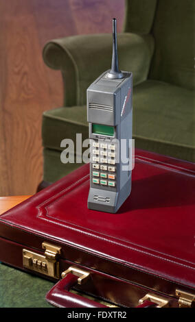 1987 OLD MOBILE CELLPHONE CITYMAN first generation hand held mobile cell vintage Mobira Cityman 1320 with 1980's business briefcase & chair Stock Photo