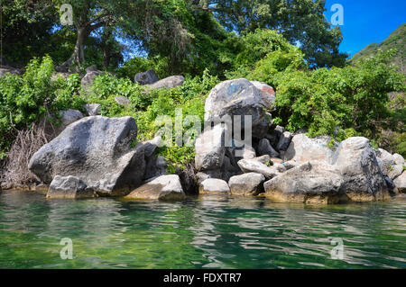 Rocky coast of the volcanic caldera Lake Coatepeque in Salvador Stock Photo