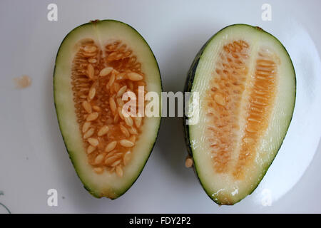 Wild melon, Cucumis melo var agrestis, fruit section, bari kachri, oval fruit, green skin, dark green patches, pale green flesh Stock Photo