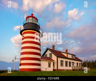 Lubec, Maine: West Quoddy Head Light at dawn with pink clouds Stock Photo