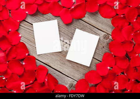 Valentines day blank photo frames over wooden background and red rose petals Stock Photo