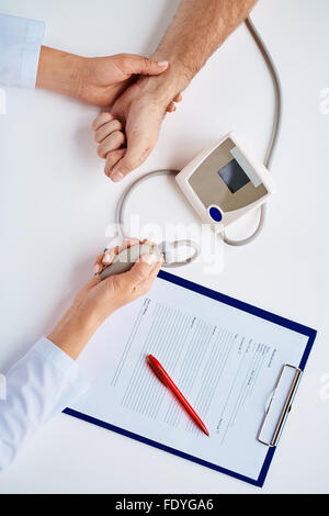 Hands of doctor measuring blood pressure of patient Stock Photo