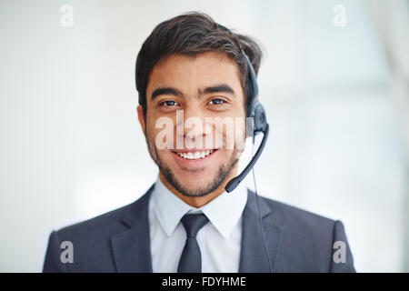 Young businessman with headset looking at camera Stock Photo