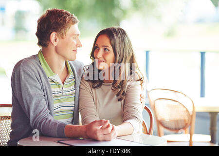 Young smiling couple having rest in cafe