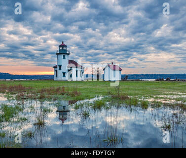 Vashon-Maury Island, WA: Point Robinson Lighthouse reflecting in a small pond at sunrise with storm clouds Stock Photo