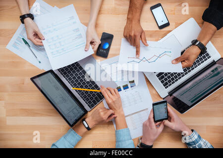 Team of colleagues working for financial report using laptops and smartphones Stock Photo