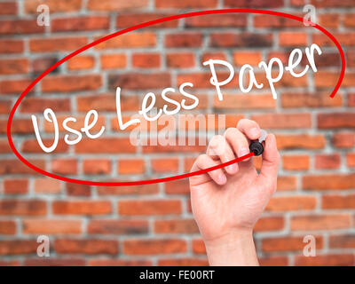 Man Hand writing Use Less Paper with black marker on visual screen. Stock Photo