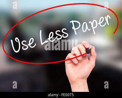 Man Hand writing Use Less Paper with black marker on visual screen. Stock Photo