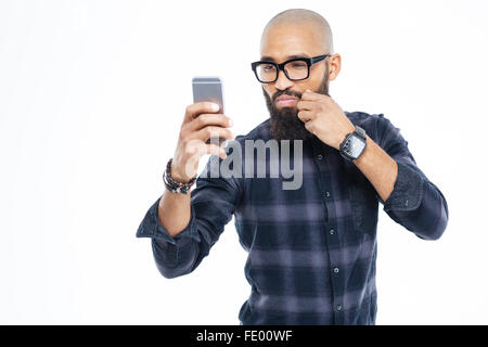 Attractive baldheaded african american man in glasses touching moustache and taking selfie Stock Photo