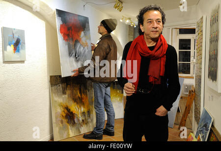 Bremen, Germany. 01st Feb, 2016. Syrian artist Naser Nassan Agha (R) stands amongst some of his pictures in the ART15 gallery in Bremen, Germany, 01 February 2016. Gallery owner Harm Wicke stands in the background. A selection of his pictures will be shown in an exhibition from 05 February to 21 February 2016. The successful painter had to flee his home and has been living since the end of 2015 as a refugee in Bremen. Photo: Ingo Wagner/dpa/Alamy Live News Stock Photo