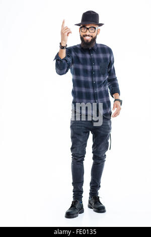 Full length of happy handsome african american man in hat standing and pointing up Stock Photo