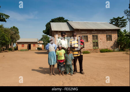 Prosperous and happy looking Ugandan family in front of their rural home. Stock Photo