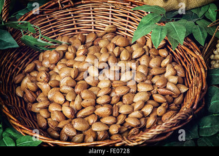 Closeup photo of almonds in wicker bowl. Healthy food. Stock Photo