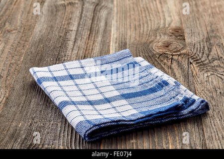 Folded napkin isolated on wooden table Stock Photo